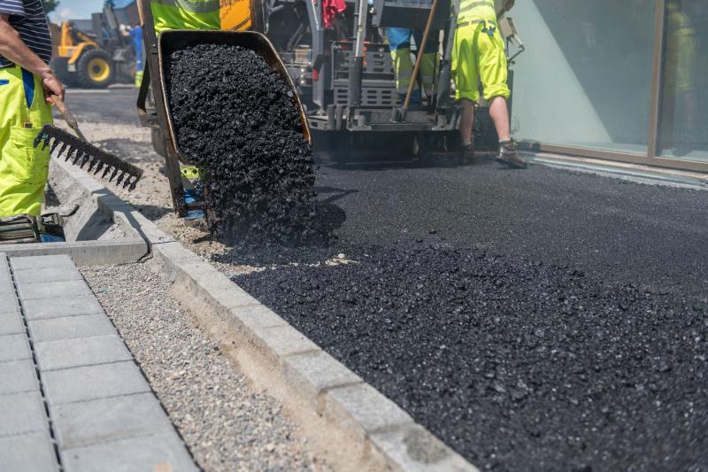asphalt contractor team laying fresh pavement
