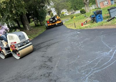 Freshly paved street with road roller and asphalt_finisher in action